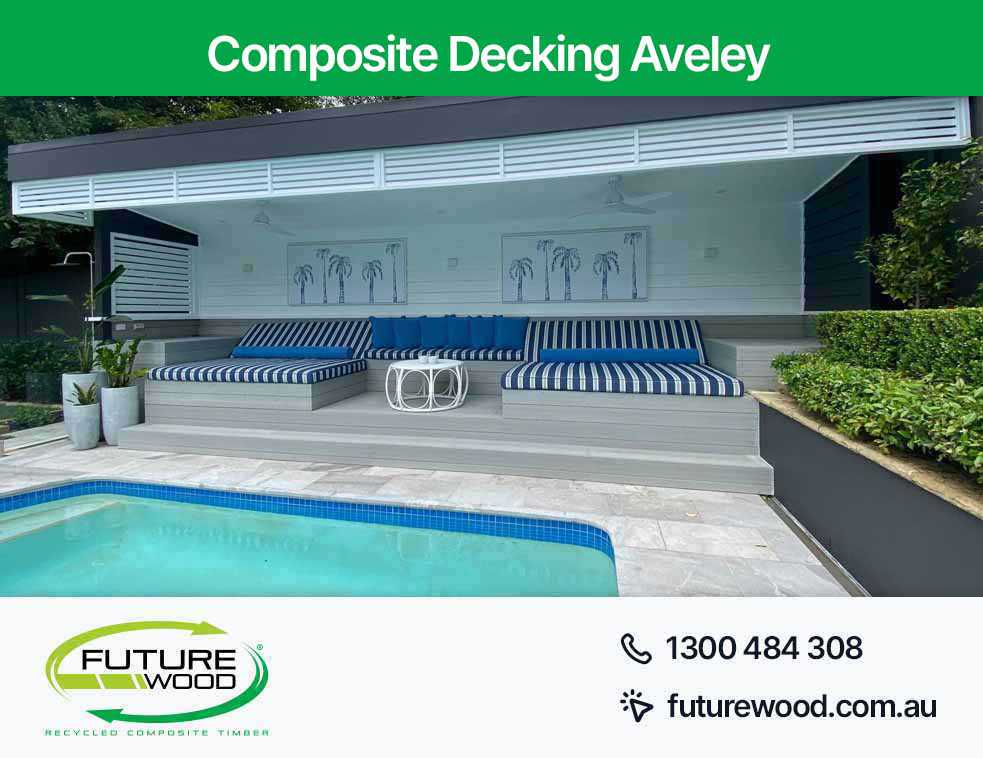Image of composite deck boards on a pool with blue and white cushions in Aveley