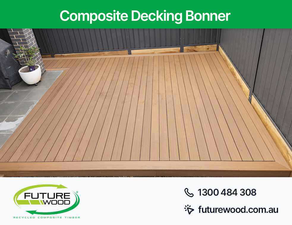 Image of composite deck boards on patio with black wall in Bonner
