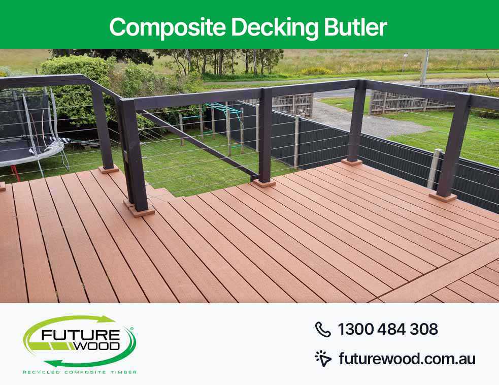 A balcony made of composite decking boards with railing and fence in Butler