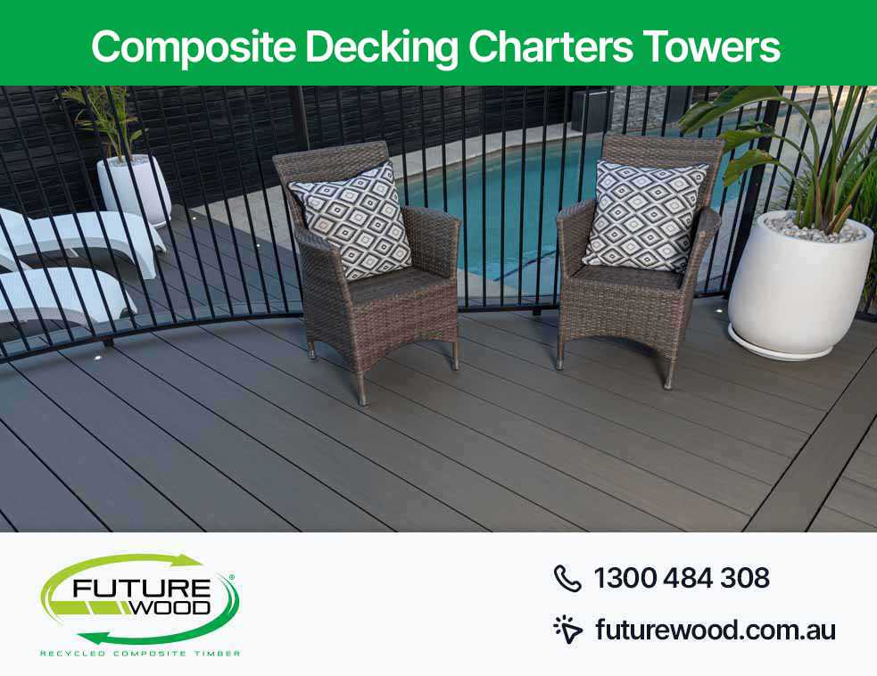 Two wicker chairs on a composite deck boards near a pool in Charters Towers