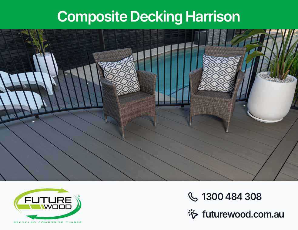 Two wicker chairs on a composite deck boards near a pool in Harrison