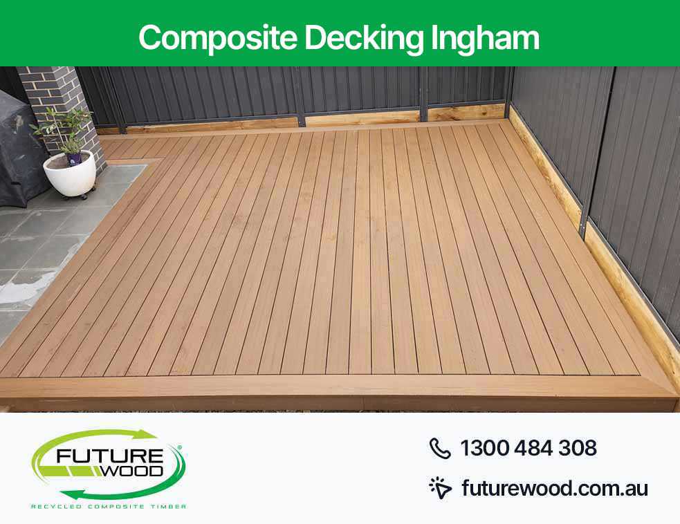 Image of composite deck boards on patio with black wall in Ingham