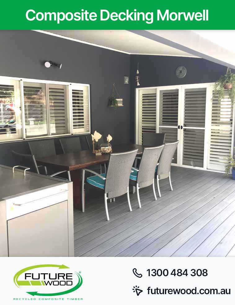A composite deck boards featuring a table and chairs for outdoor relaxation in Morwell